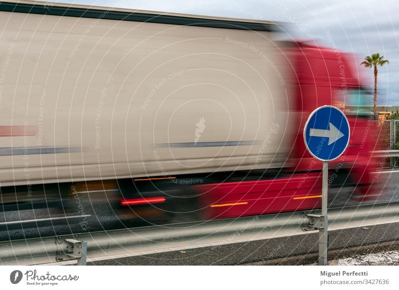 Mandatory sign with a moving truck in the background Truck Logistics Road traffic Colour photo Driving Vehicle Speed semi motorway traffic signal Unique sense