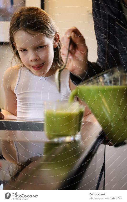 Little girl watches green smoothie being poured into a glass and is looking forward to it Child Infancy Delicious salubriously Beverage Glass Carafe Self-made