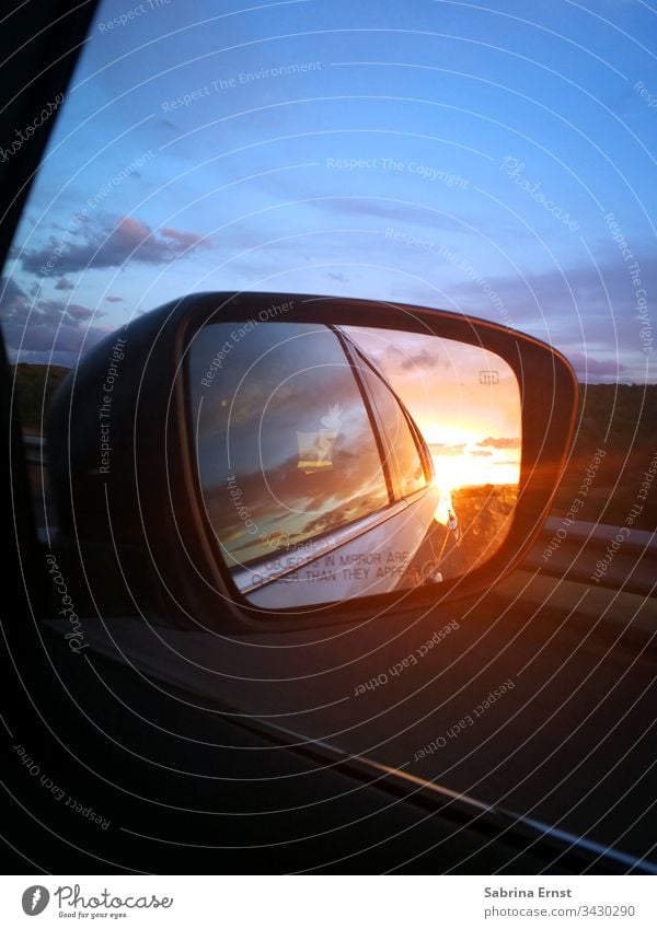 Reflection of a sunset in the exterior mirror car mirrors Car Sunset colourful Light Transport Street Highway travel road trip Review panorama Landscape