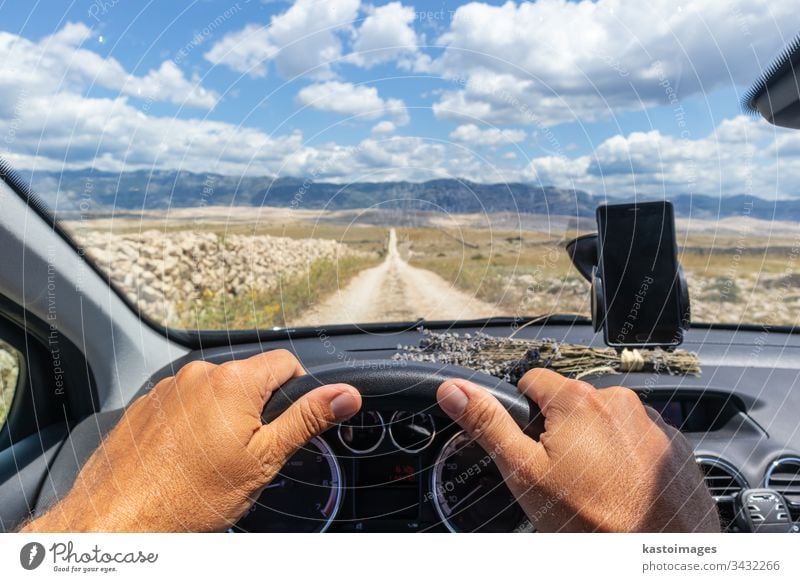 Detail of male driver hands on steering wheel. Driving a car on country road. View from the cabin trough the windshield. dashboard front holding inside light