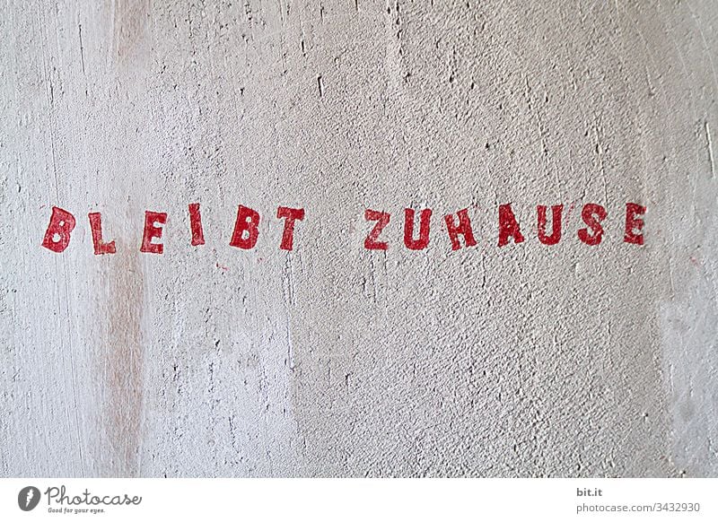 Stays at home, red lettering stamped on white wall. COVID Quarantine prevention coronavirus Contagious infectious Signage guard sb./sth. Epidemic peril Clue