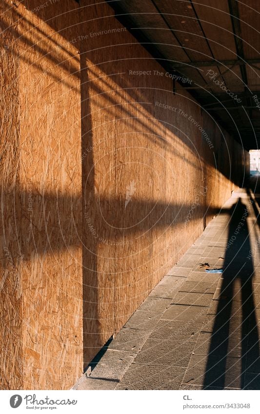 long shadow of a person on the sidewalk Shadow Corridor off Construction site Wood Mysterious Protective gloves Tunnel Tunnel vision Scaffolding