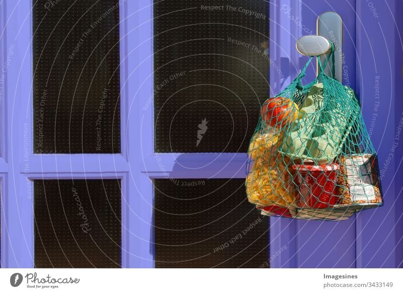 contactless purchase delivery during quarantine. shopping bag with goods and food hangs on the front door, neighbourhood support - concept for quarantine period due to coronavirus infection Covid-19