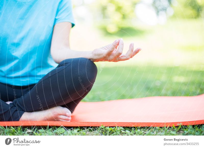 Senior woman in a lotus position   on a grass senior park health exercise beautiful yoga mature person fit female outdoors elderly adult people fitness nature