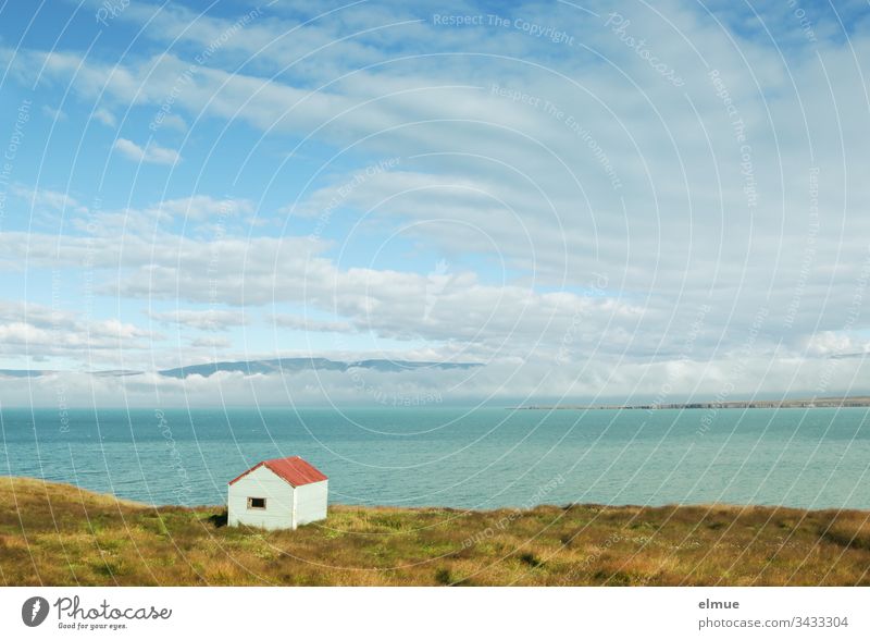 small hut on the shore and view over the water to cloudy mountains (Iceland) Hut Water bank Reykir Lonely Loneliness Exterior shot Nature