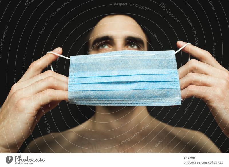 Portrait of a man with medical facial mask who is concerned about preventing pandemic coronavirus on a gray background. quarantine and pandemic concept. Man wearing aseptic mask to prevent illness.