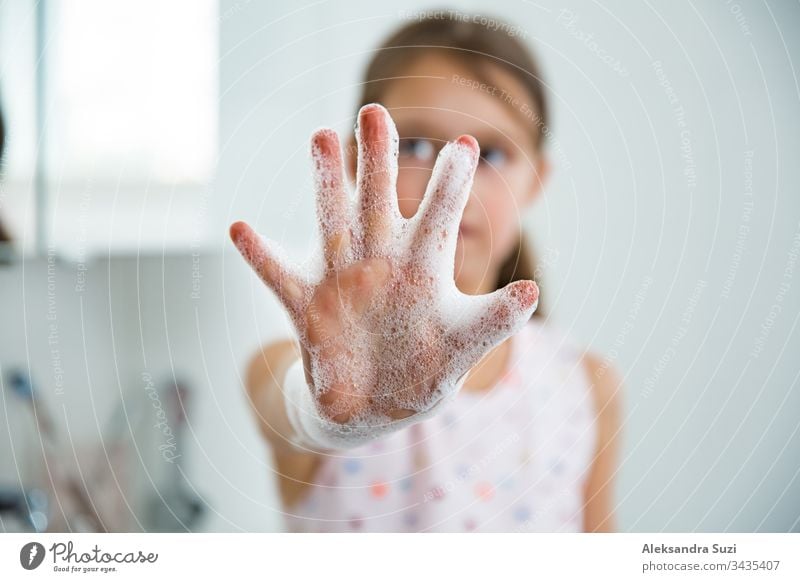 Little girl washing her hands with soap and water in the bathroom. Hand hygiene and prevention of viral infections. Enchanting Bacterium Bathroom Bubble care