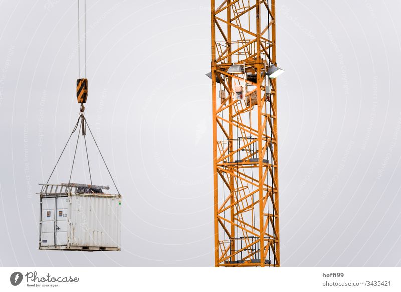 Aluminium ladder on floating container on the load hook of a crane Construction site Crane Ladder construction site supply Work and employment Craft (trade)