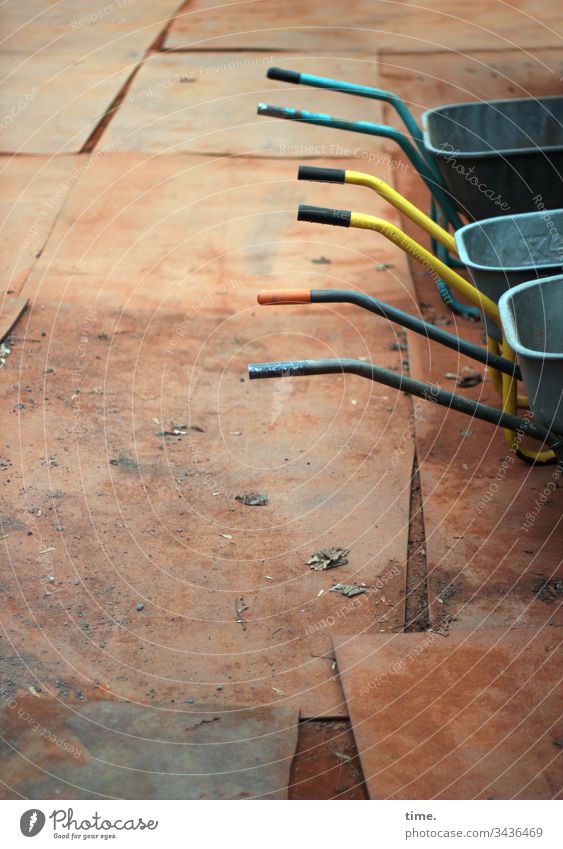 Cart in the dirt | triad Wheelbarrow pushcart Construction site Floor covering Paving tiles filth Red Partially visible zinc handrail turned off Break