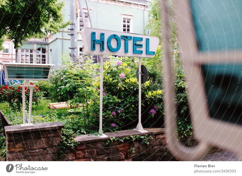 Typographic hotel sign on a flowering garden in a driveway Typography Letters (alphabet) Signs and labeling Hotel Advertising Word Signage Characters travel