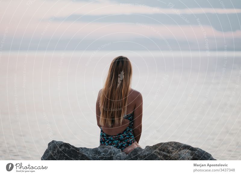 Young woman enjoying sunset on the beach alone beautiful calm coast dawn dreamy dusk enjoyment evening female freedom future girl holiday horizon landscape