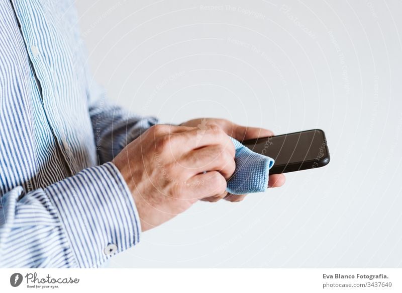 close up view of a man cleaning mobile phone with disinfectant. Hygiene and coronavirus covid-19 concept corona virus hygiene screen anti bacterial soap liquid