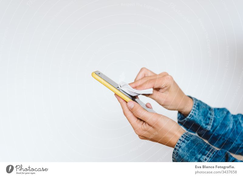 close up view of a woman cleaning mobile phone with disinfectant. Hygiene and coronavirus covid-19 concept corona virus hygiene screen anti bacterial soap