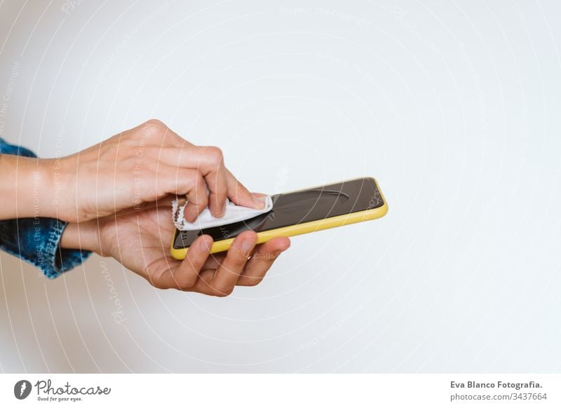 close up view of a woman cleaning mobile phone with disinfectant. Hygiene and coronavirus covid-19 concept corona virus hygiene screen anti bacterial soap