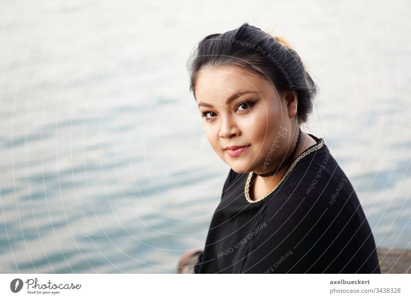 young asian woman by the water girl smile smiling lake pond sea river happy cheerful happiness confident nature elegant vietnamese outdoor outside chubby