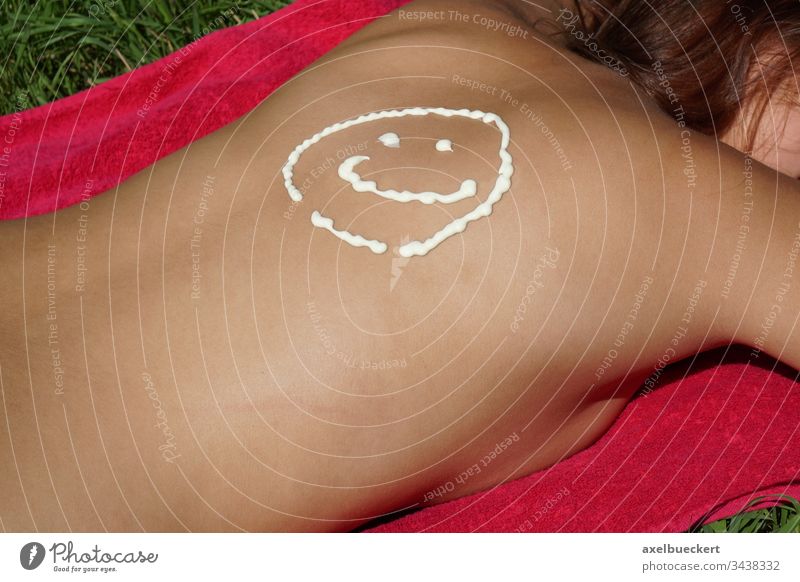 suncream smiley on female back sunbathing sunscreen suntan woman girl sunbather tanning sunblocker lotion sunburn skin protection prevention vacation summer fun