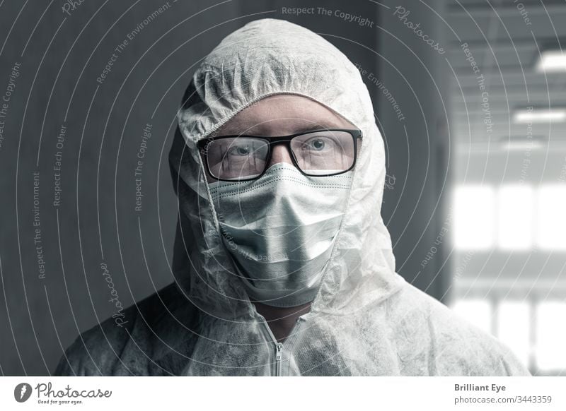 Portrait of a medical doctor in a protective suit and with reflective glasses, depicting an empty hospital care concept coronavirus Corridor Empty peril Dark