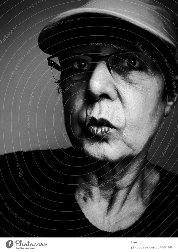 With big eyes the old woman stared into the future, but neither the baseball cap nor the glasses helped, she just couldn't see anything. Woman