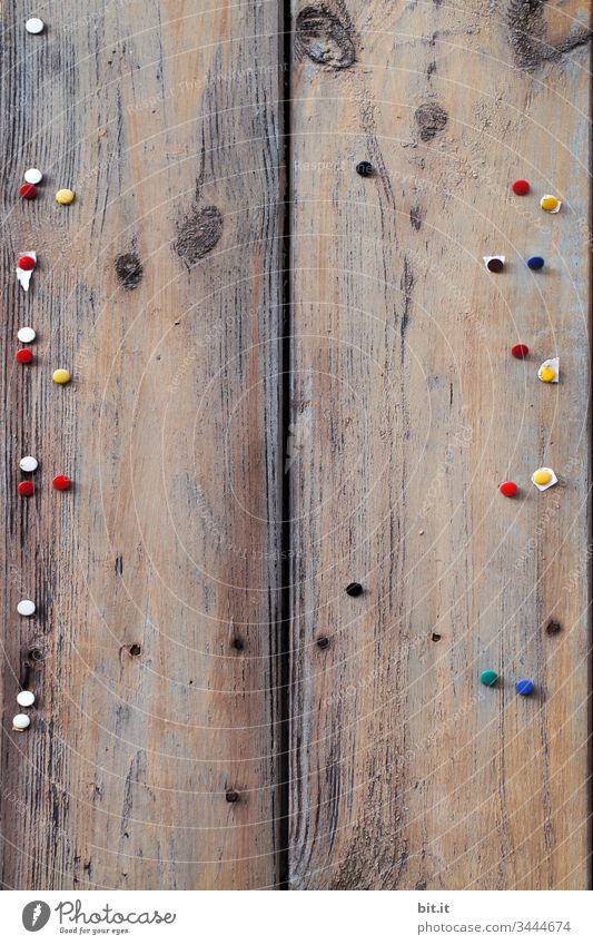 Many, colorful rice nails are stuck on an empty, old wooden board. Wall (building) Bulletin board Trashy Old wear Ravages of time Staple Gloomy Information