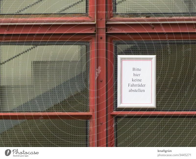 Information sign "Please do not park bicycles here" attached to a wired glass pane of a staircase Prohibition sign Communicate Compromise Signs and labeling