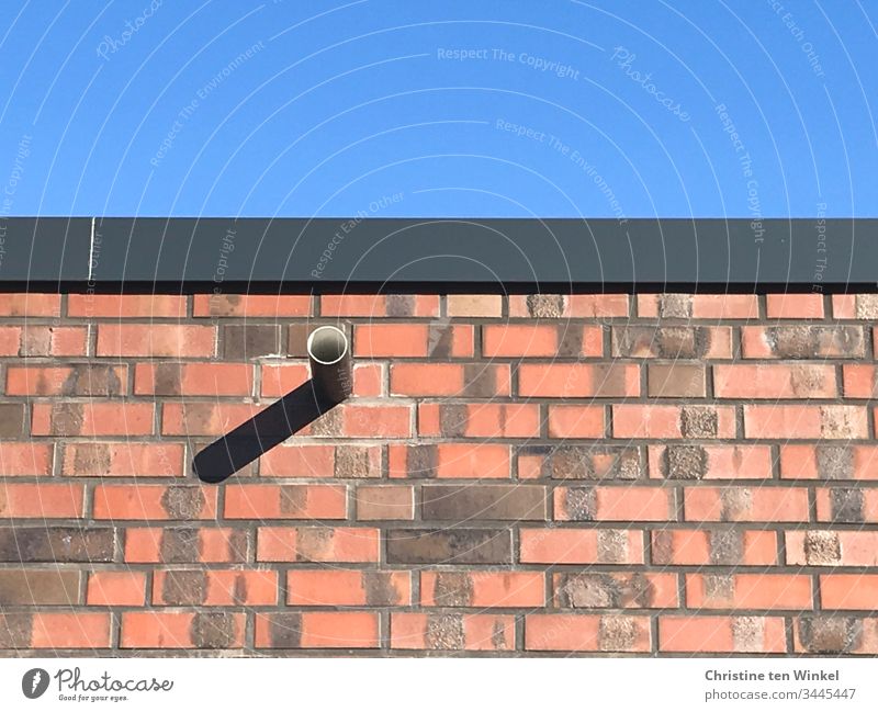 red clinker brick facade with rain drainage and shadows against blue sky Wall (barrier) Facade facing brick Red Blue sky Light and shadow Sunlight