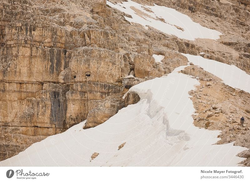 Single man walking off the path along a steep mountain slope Dolomites South Tyrol mountains Rock harsh Human being Man Individual going Gravel positions Snow