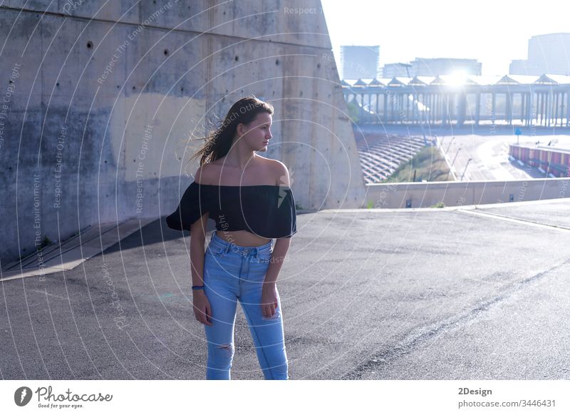 One young beautiful woman with long hair standing on promenade while looking pensive to camera outdoors posing lifestyle attractive pretty 1 thoughts daylight