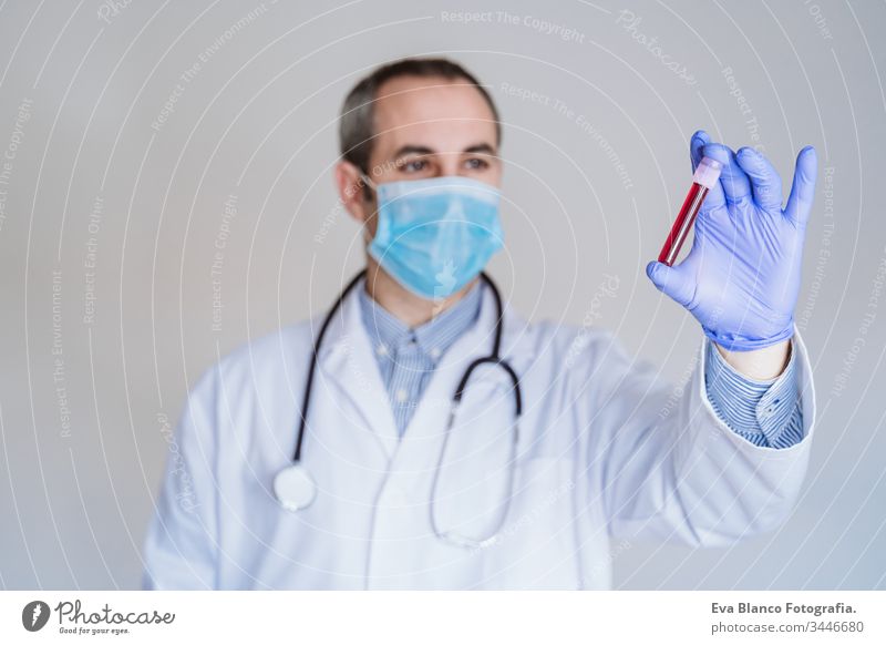 caucasian doctor man holding test tube with blood for 2019-nCoV analyzing. Chinese Coronavirus blood test concept. Covid-2019 coronavirus covid 2019