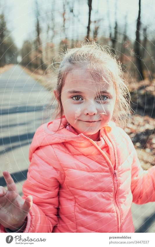 Portrait of little girl playing in the park, having fun on sunny autumn day. Real people, authentic situations kid child happy outdoors childhood forest person