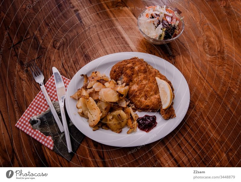 Wiener Schnitzel with fried potatoes viennese schnitzel Hash brown potatoes Bavaria Austria tribunal Down-to-earth Eating enjoyment Lettuce Meat breaded