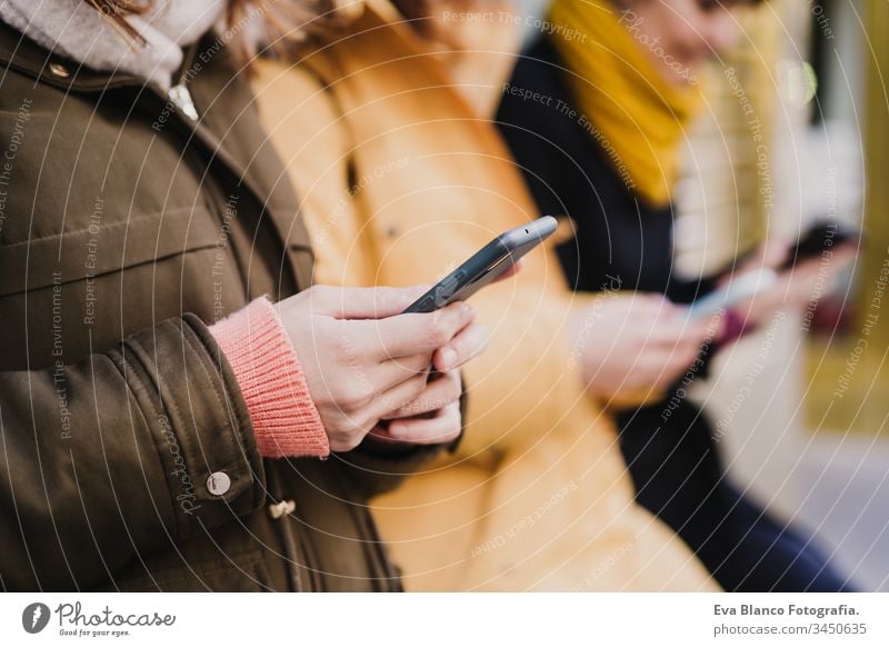 group of friends using mobile phone outdoors in the street. lifestyle and travel concept unrecognizable friendship tourist tourism three 3 technology city urban