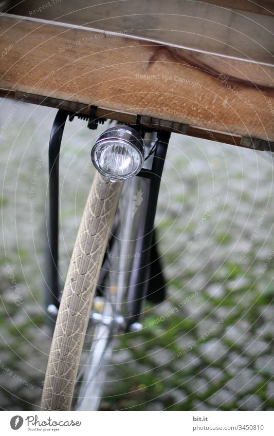 Lamp over the front wheel of a bicycle with wooden box for transport, shopping, on cobblestone. Wheel Driving Bicycle Front wheel Cycling Lanes & trails