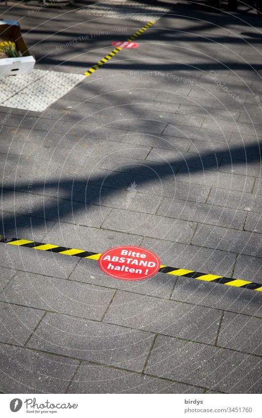 Distance markings in front of a supermarket. Customers are asked to keep their distance because of the risk of infection by the coronavirus. Covid 19