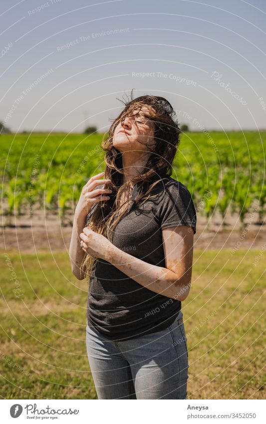 A young woman outside on a windy day 2017-2020 first import messy hair contentment happiness windy weather adventure daytime daylight freedom Free-living