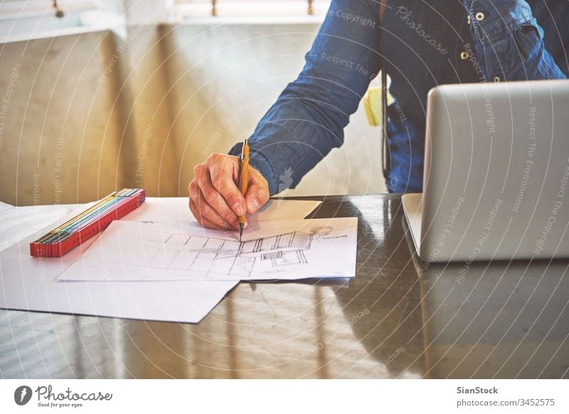 Architect man sketching a kitchen in his office laptop business breakfast workplace computer hands keyboard desk table working technology notebook up writing