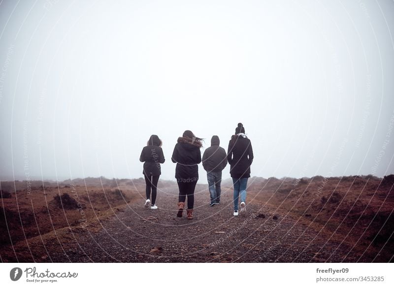 Four people hiking with fog active background cold copyspace foggy landscape four friends friendship fun group happy lifestyle mist outdoor sky summer top