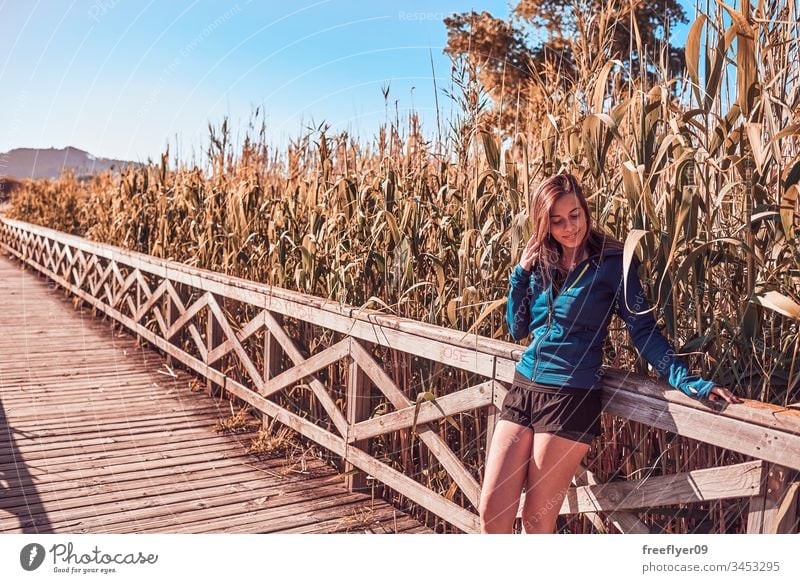 Young woman walking by a wood footbridge Playa America adventure body female forest freedom girl healthy landscape landscaped lifestyle long hair model natural