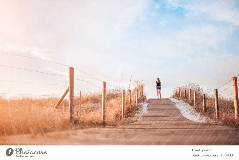 Young woman on the top of a dune on Vao beach in Vigo, Spain active attractive blue break breeze bridge bright coast contemplate contemplation country docked