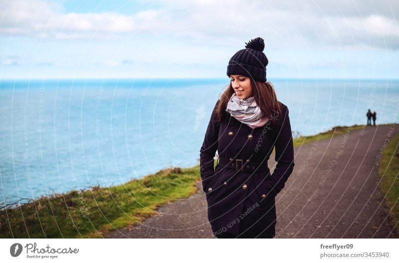 Portrait of a young woman in winter walking by the sea adventure attractive autumn away back background beautiful beauty behind black clothes cold concept day