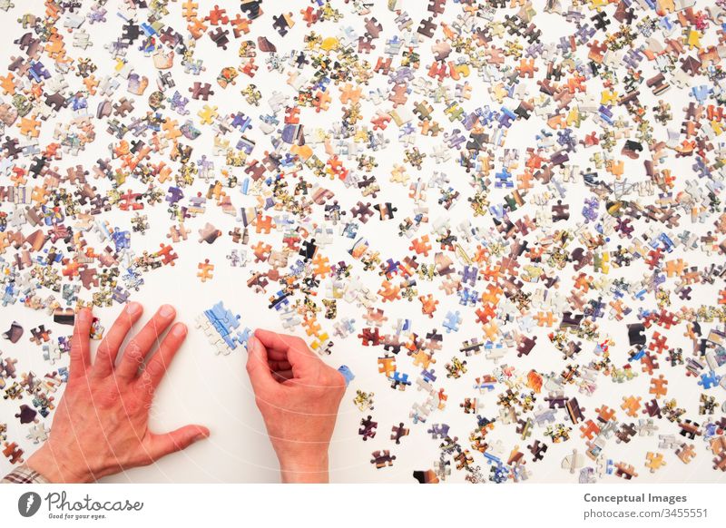 Personal perspective of a man doing a jigsaw puzzle abstract brain-teaser brainteaser challenge concept connect connection creative creativity educational