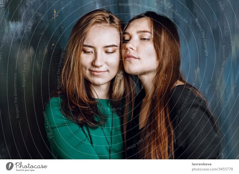 Two young adult female hugging each other, selective focus asian attractive beautiful caucasian cheerful couple eyes closed face family fashion friendship fun