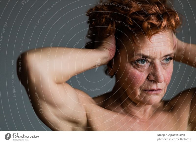 Mature woman by the window thinking about life 60s adult age aged aging alone beautiful care caucasian close-up contagion contemplating depression elder elderly