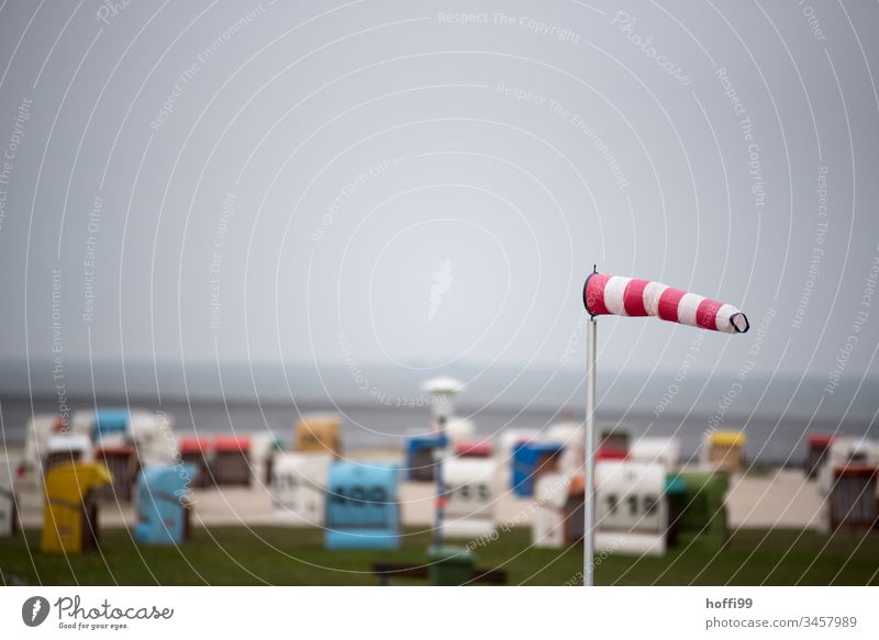 Windsock on the beach - there will be rain Gale Storm Storm warning storm front Beach Beach chair beach chairs Shallow depth of field Isolated Image Weather Sky