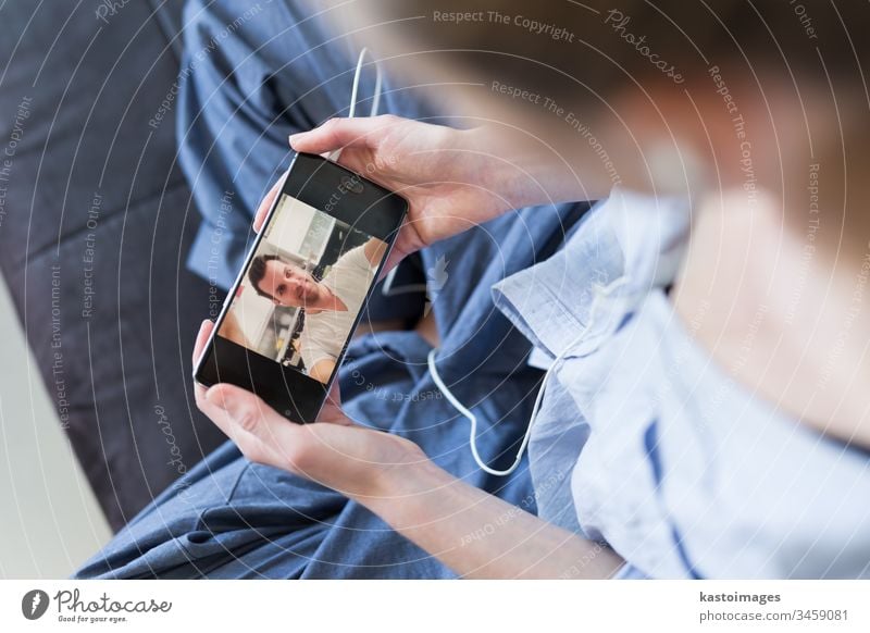 Woman at home relaxing on sofa couch using social media on phone for video chatting with her loved ones during corona virus pandemic. Stay at home, social distancing lifestyle.