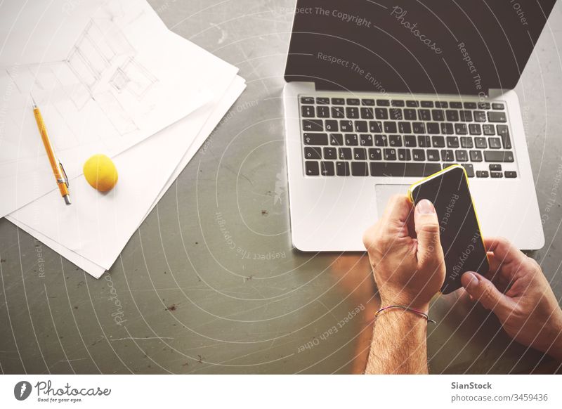 Top view of architect man working at computer and calling his client laptop business workplace hands office keyboard desk table technology notebook coffee up