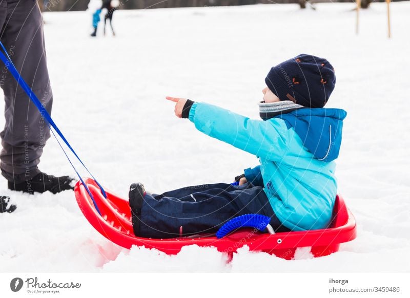 boy with red sled in the snow Winter active child childhood cold fun funny happiness happy hat holiday kids knitted leisure little mountain natural nature