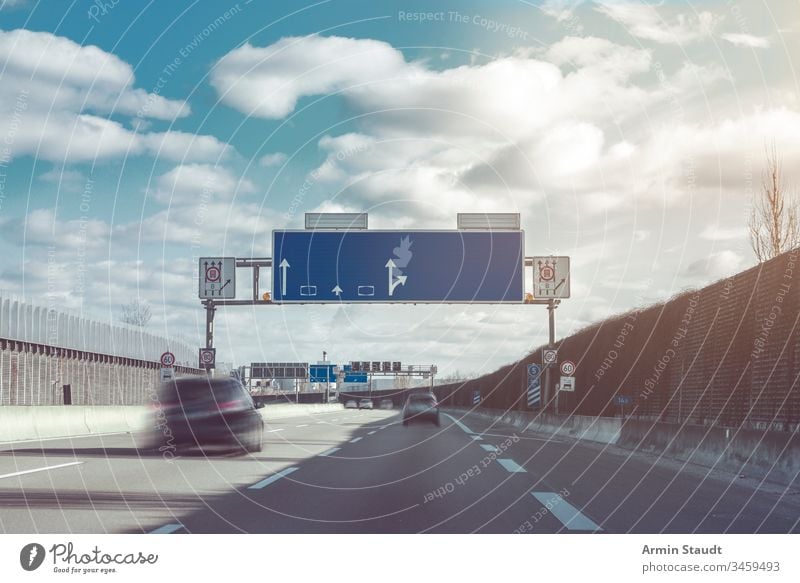 blurry cars on a german motorway blurred direction drive driving fast germany highway lane line motion motion blur movement road sign signs sky speed speedway