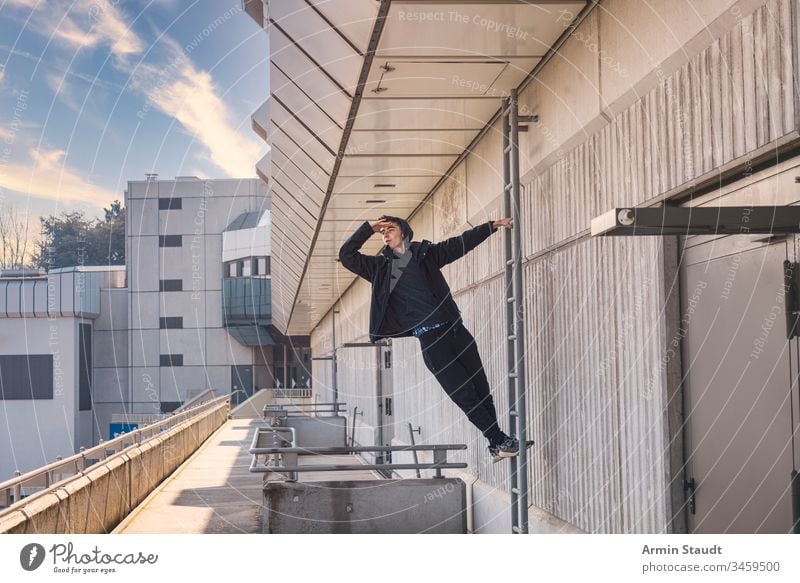 young man looking out on a ladder beautiful boy building casual caucasian climbing concrete confident eyes hand lifestyle male model outdoor outdoors portrait