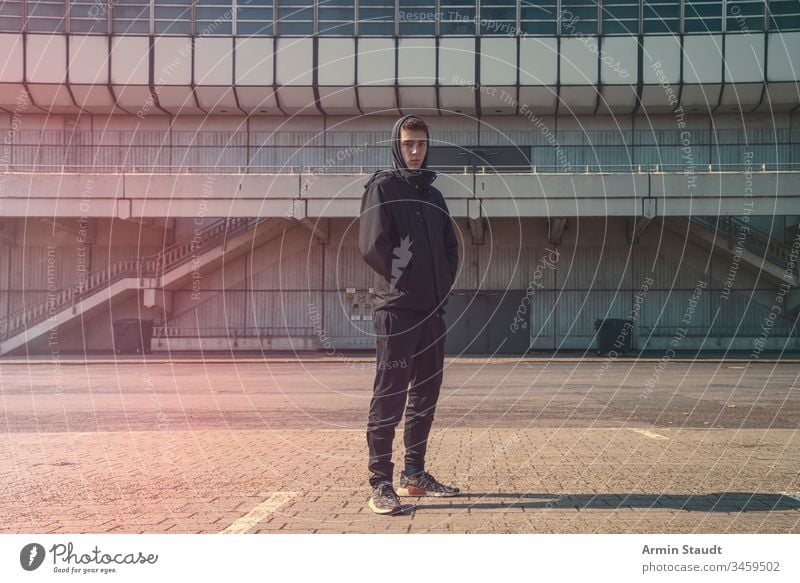 portrait of a young man with black hoodie architecture beautiful boy building casual caucasian confident lifestyle looking male model outdoor outdoors place