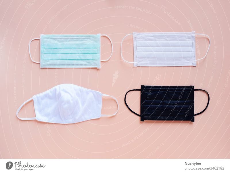 Flat lay of various kind and color of hygienic masks on bright pastel peach orange color background, health care and prevent the spread of pandemic Covid-19 and Coronavirus,